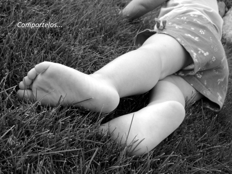 niño jugando pies hierba